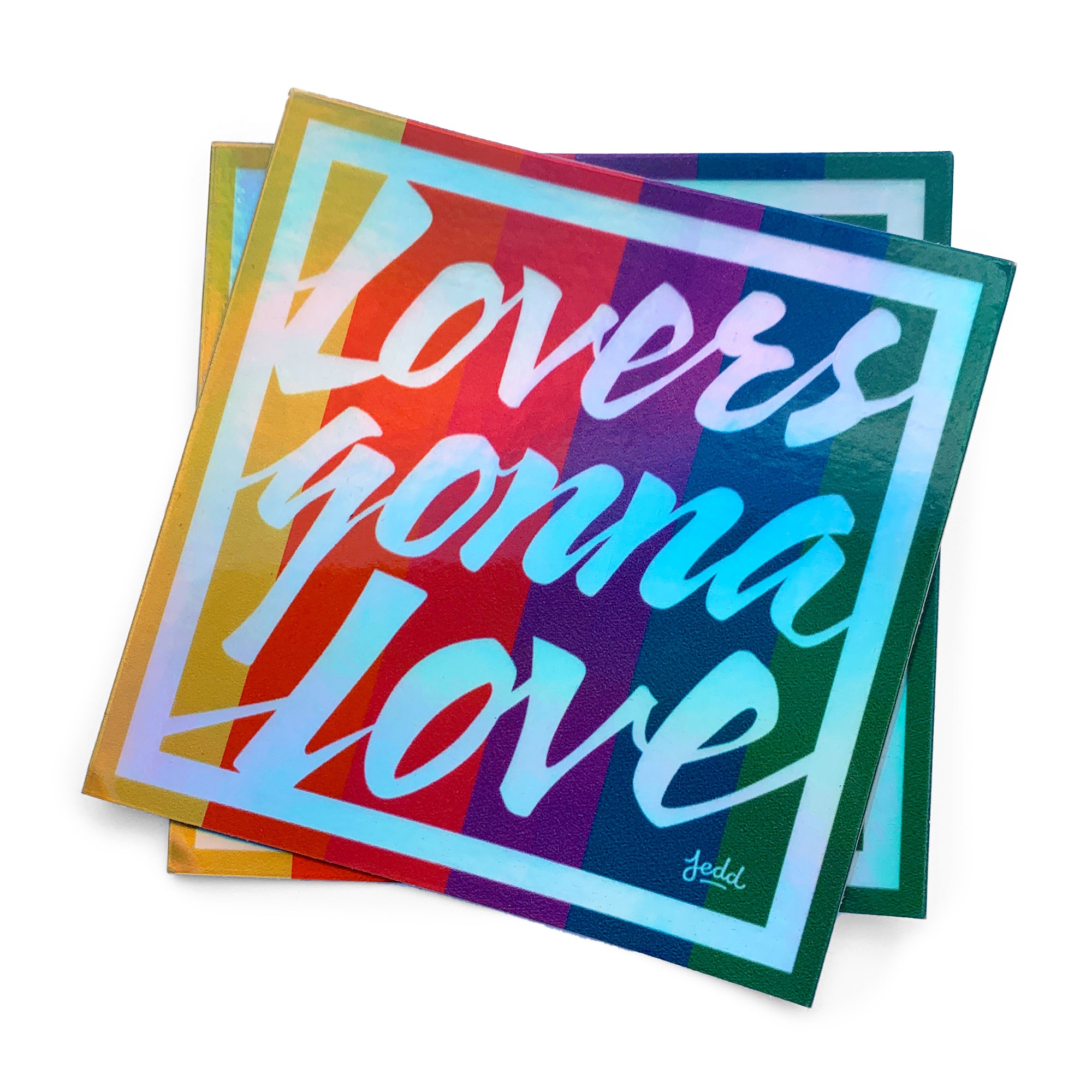 Two holographic stickers with a design that says Lovers Gonna Love
