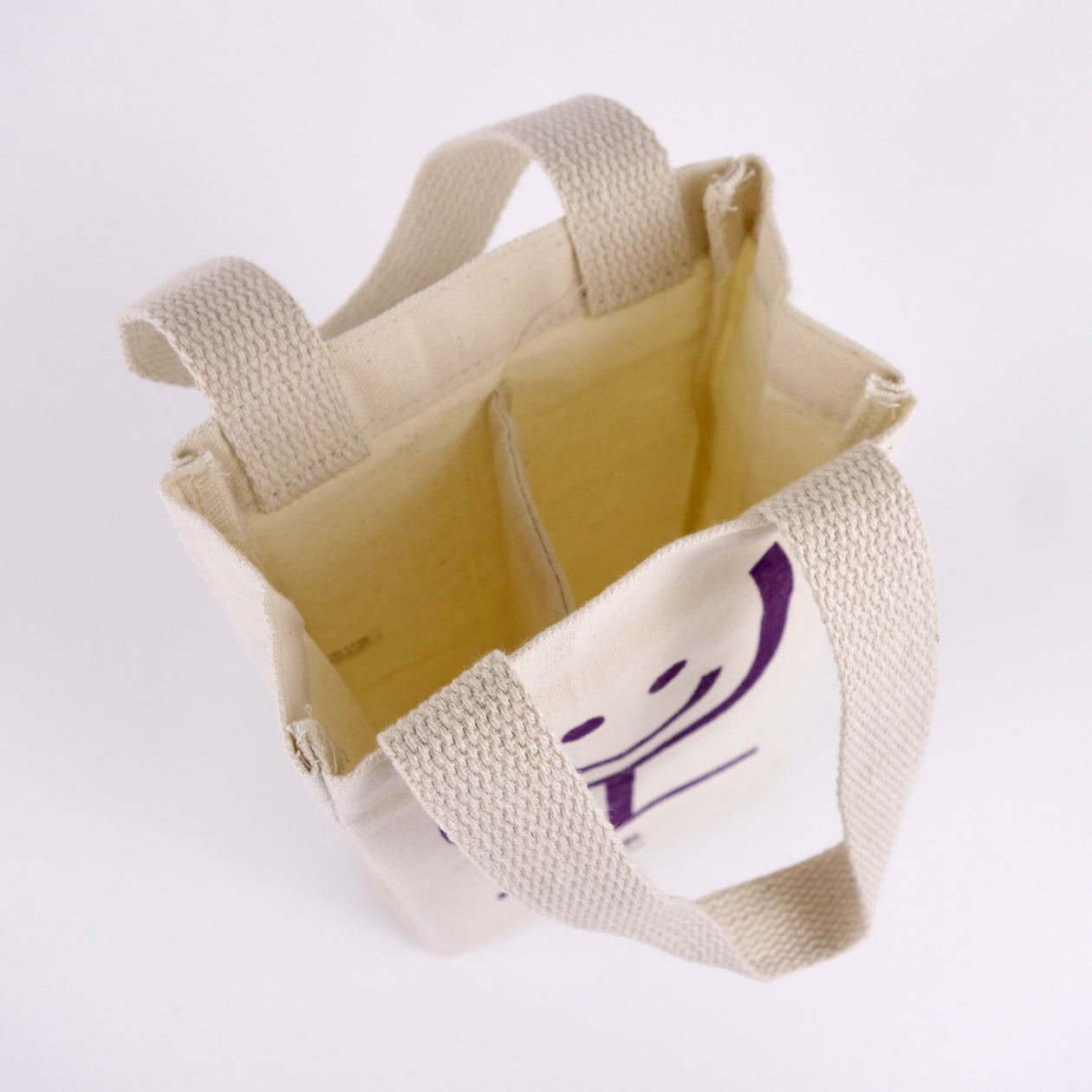 Interior detail of a canvas wine tote showing a center divider to hold two wine bottles.